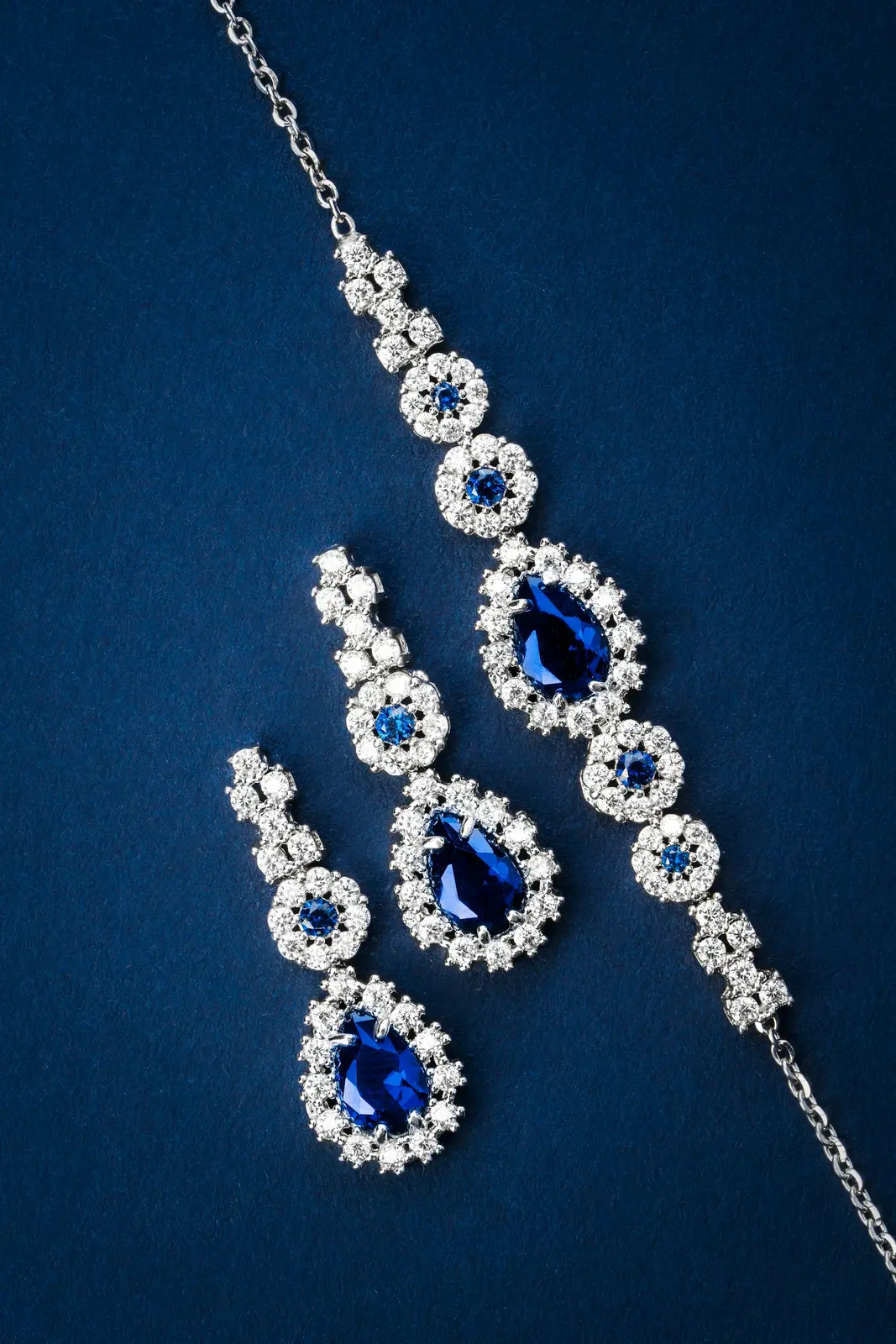 Blue gemstone necklace and earrings on a dark background