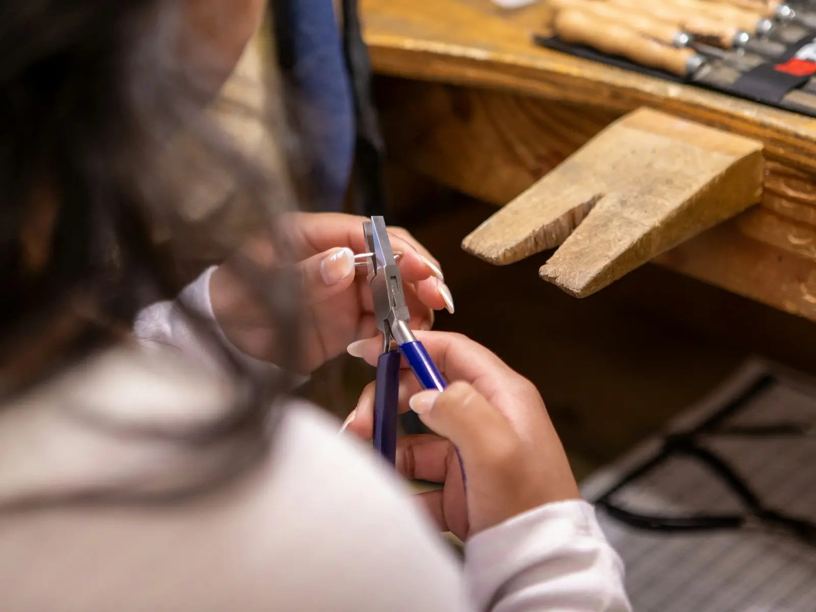 Hands doing detailed jewelry work with precision tools